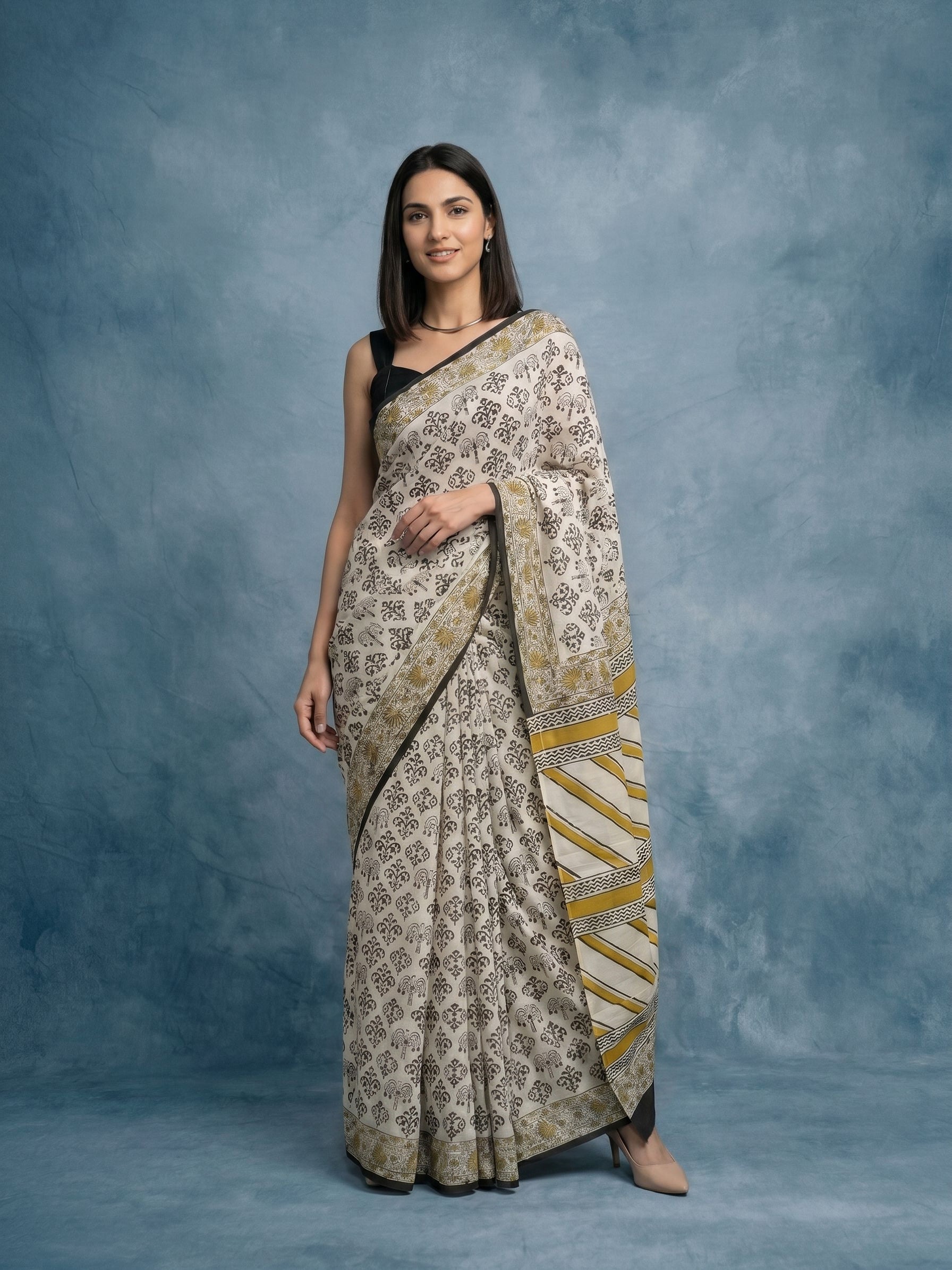 Woman wearing a patterned saree against a blue background