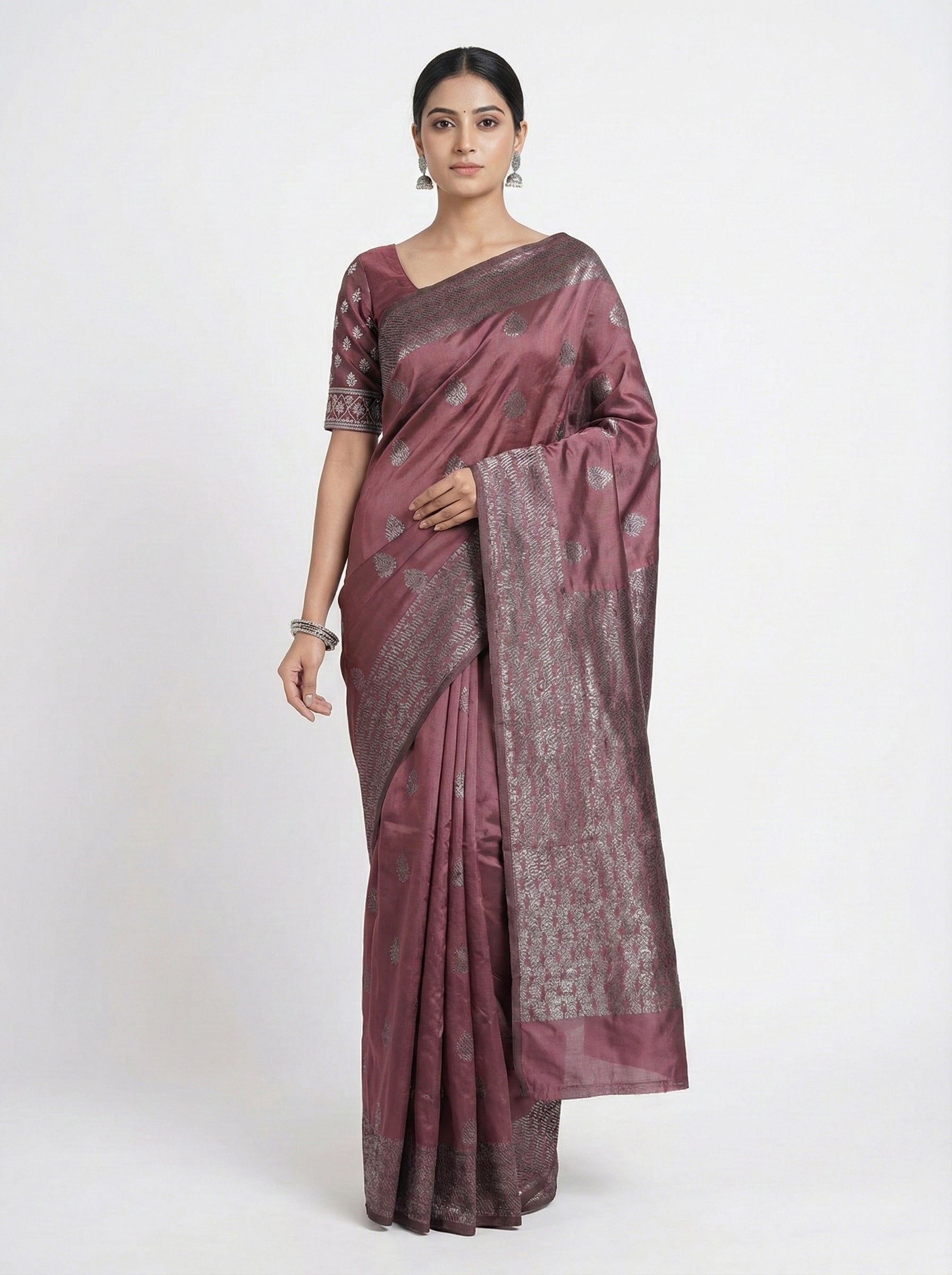 Woman wearing a maroon saree with a white background