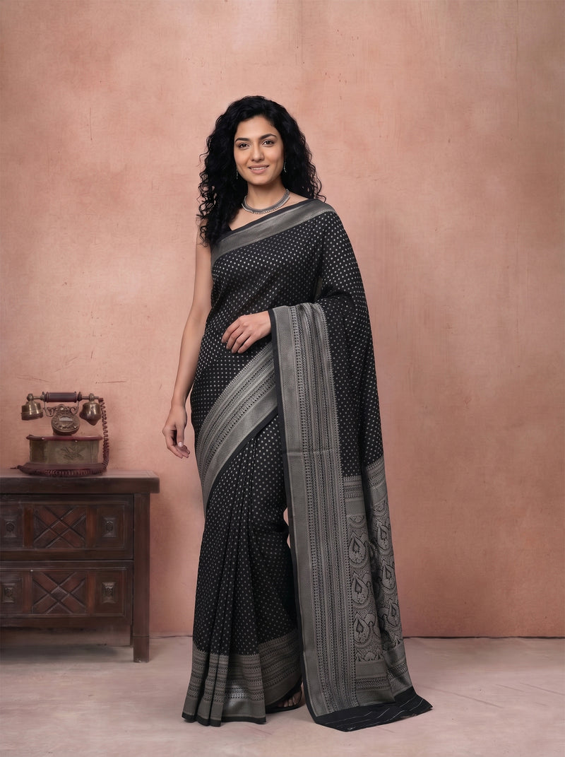 Woman wearing a black and gray saree with a pink background