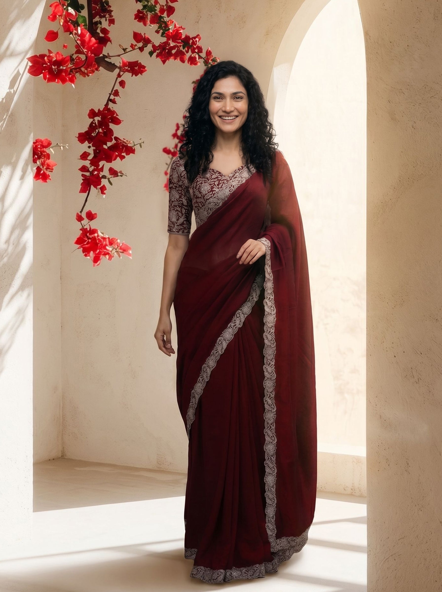 Woman wearing a maroon saree with a floral background