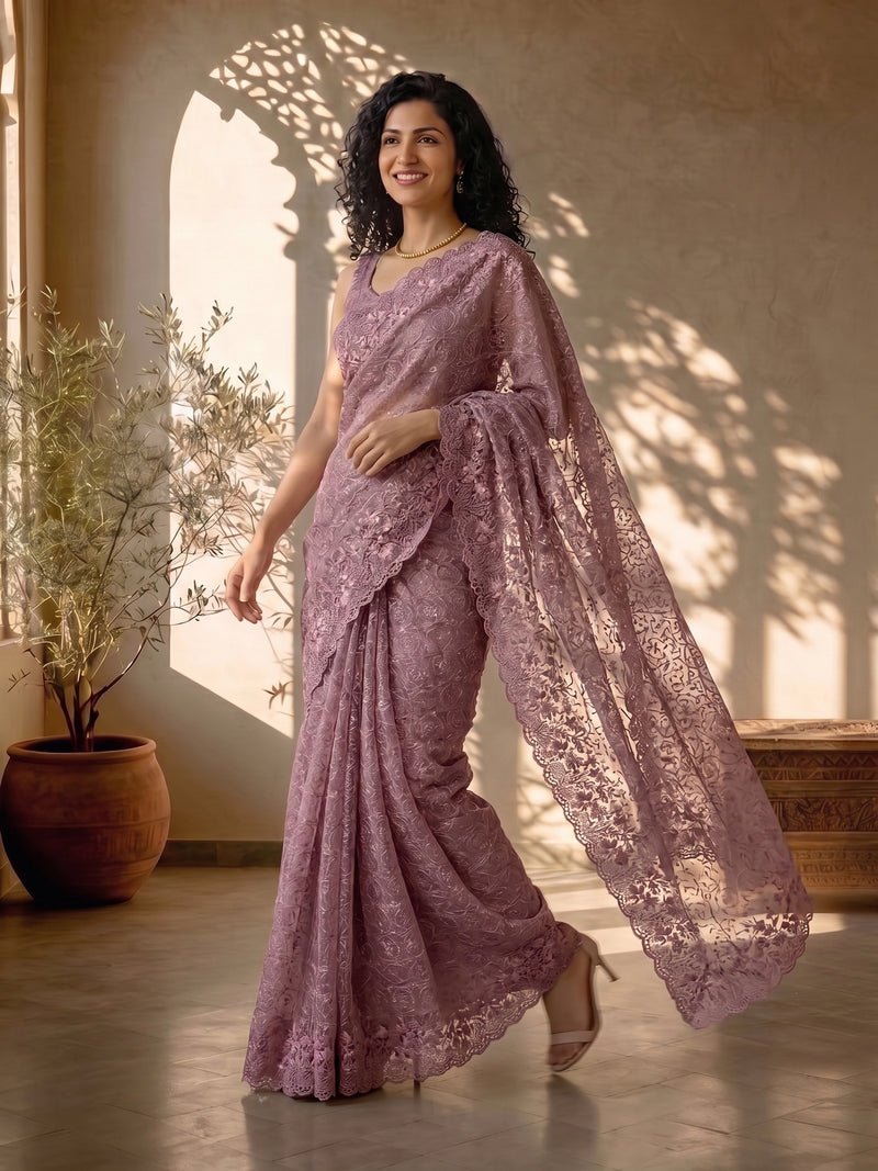 Woman in a purple saree standing indoors with natural light