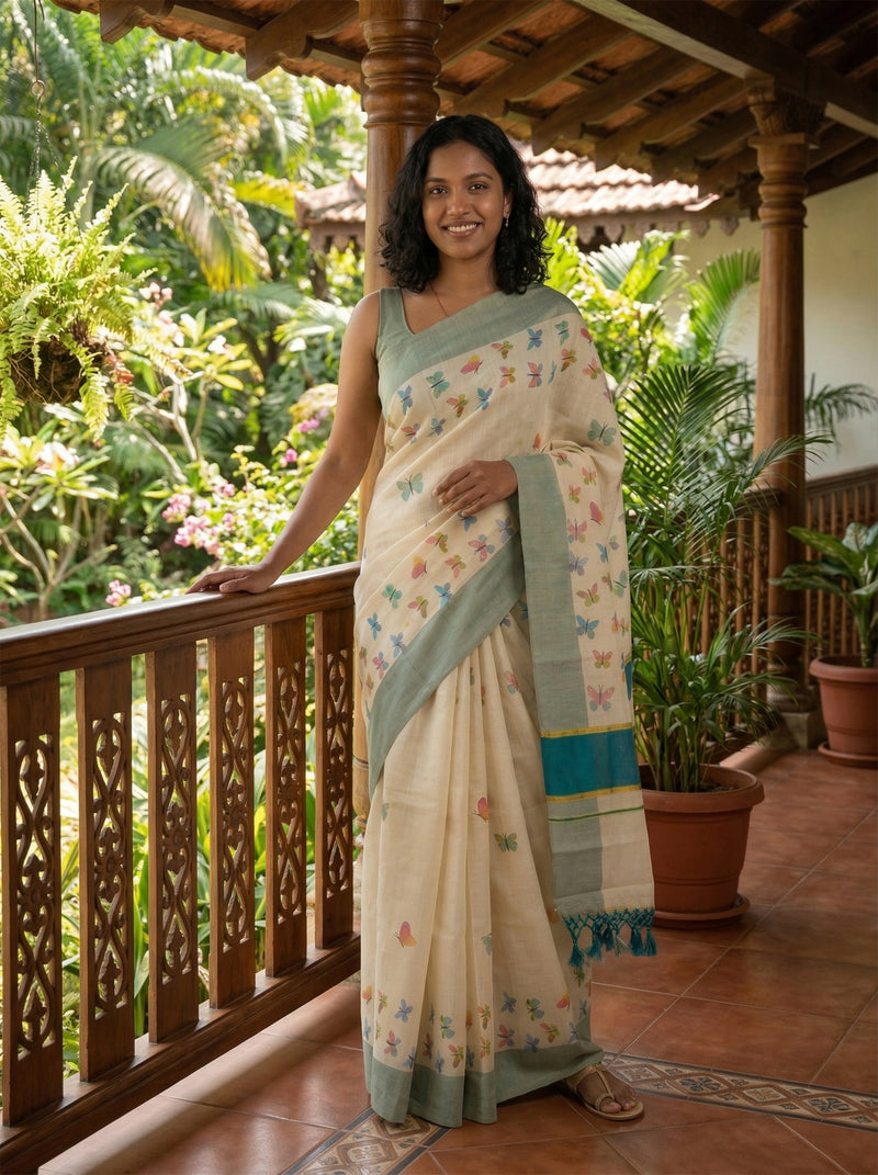 Woman in a traditional saree standing on a balcony with greenery in the background
