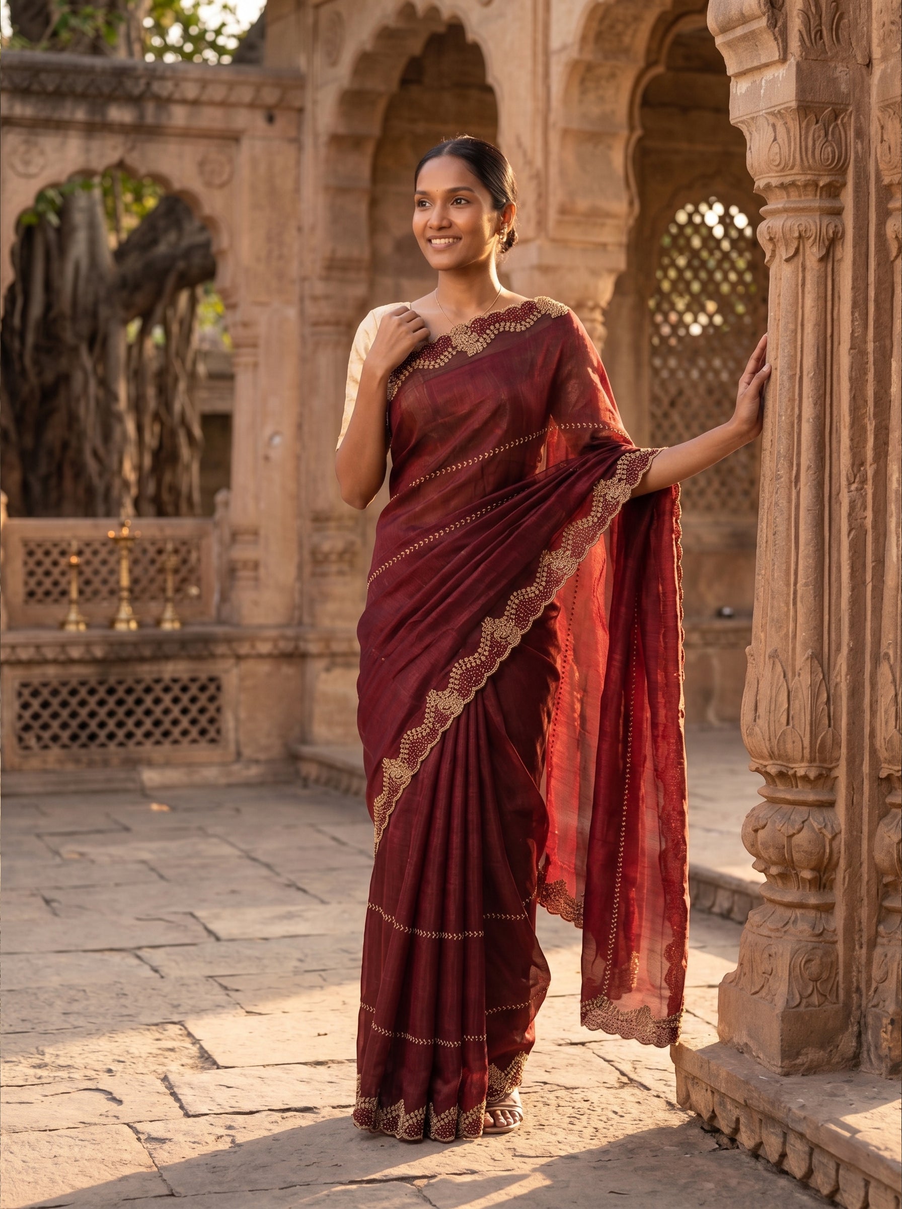 Woman in a red saree standing in an architectural setting