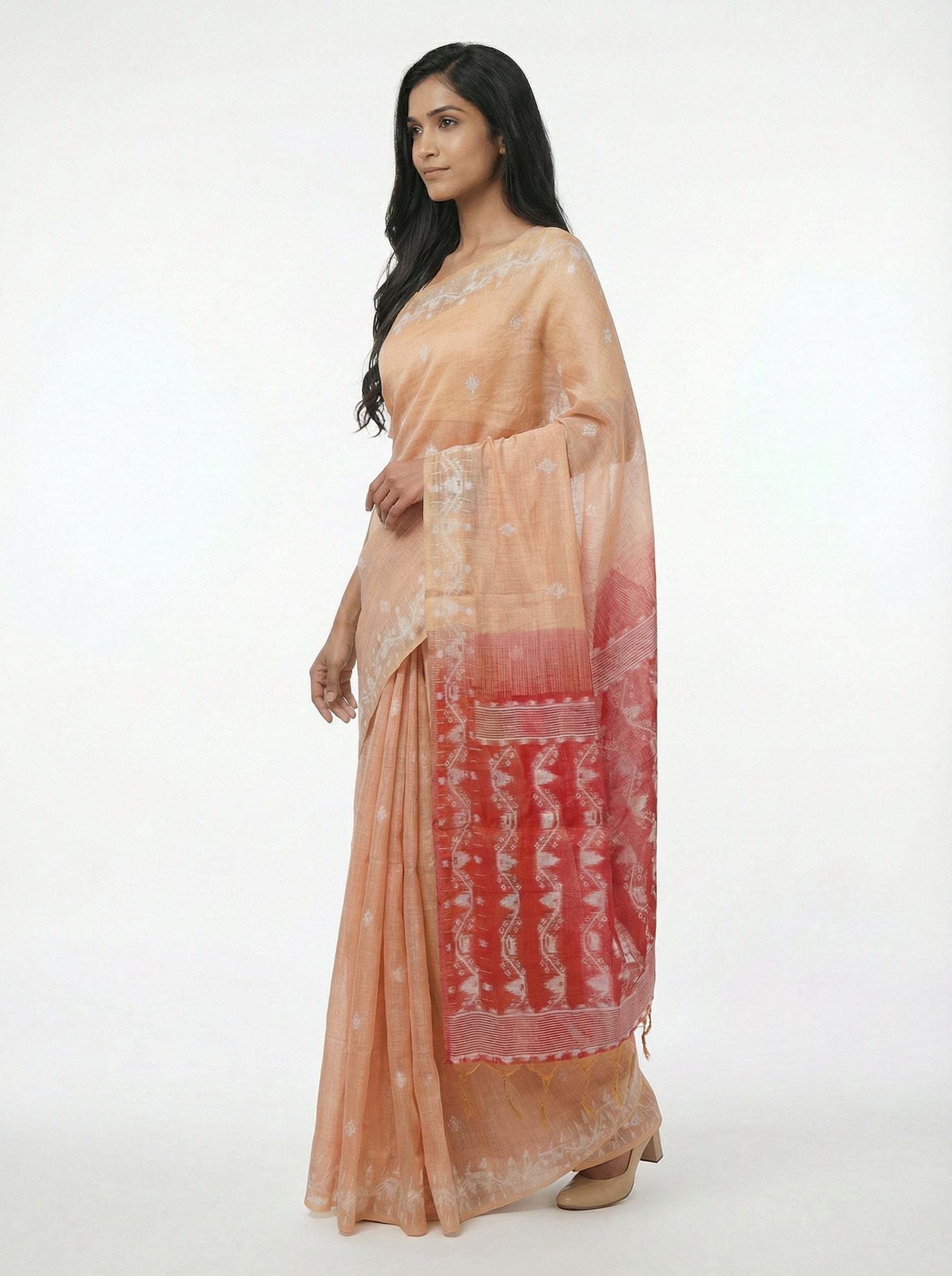 Woman wearing a peach and red saree with a white background