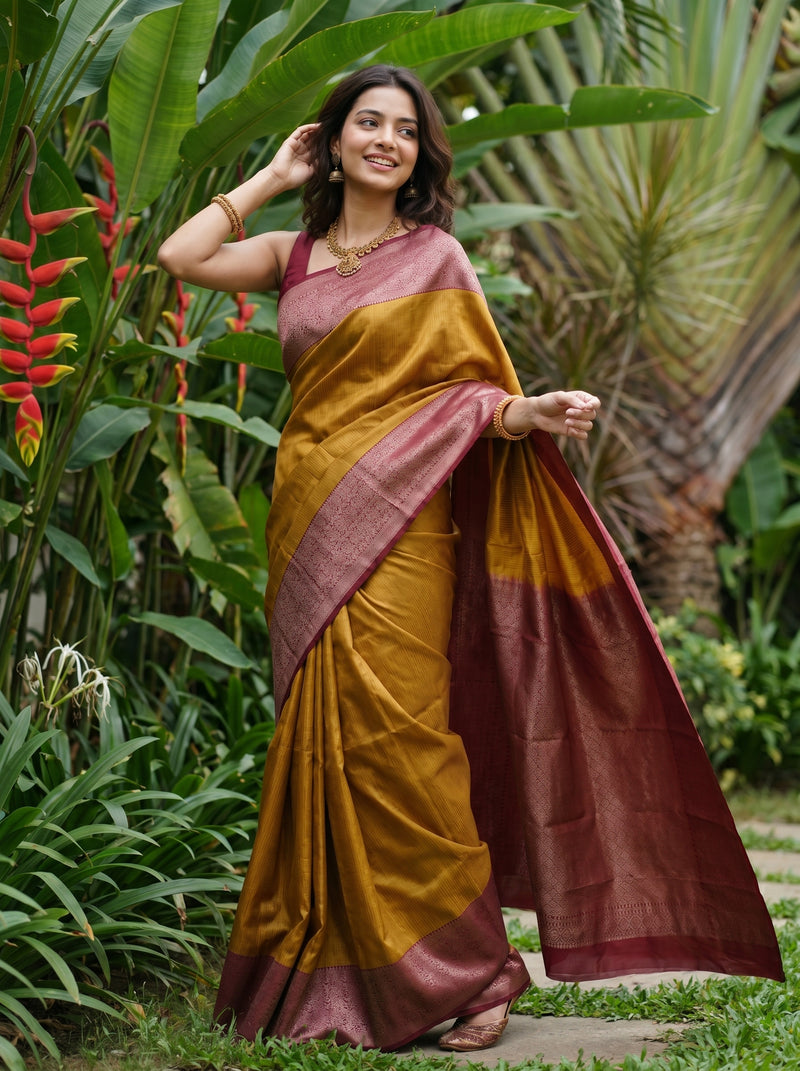 Woman in a traditional saree standing in a garden with greenery and flowers.