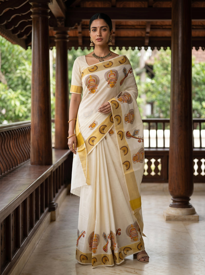 A woman wearing a cream-colored saree with yellow and brown paisley patterns, standing on a traditional wooden porch.