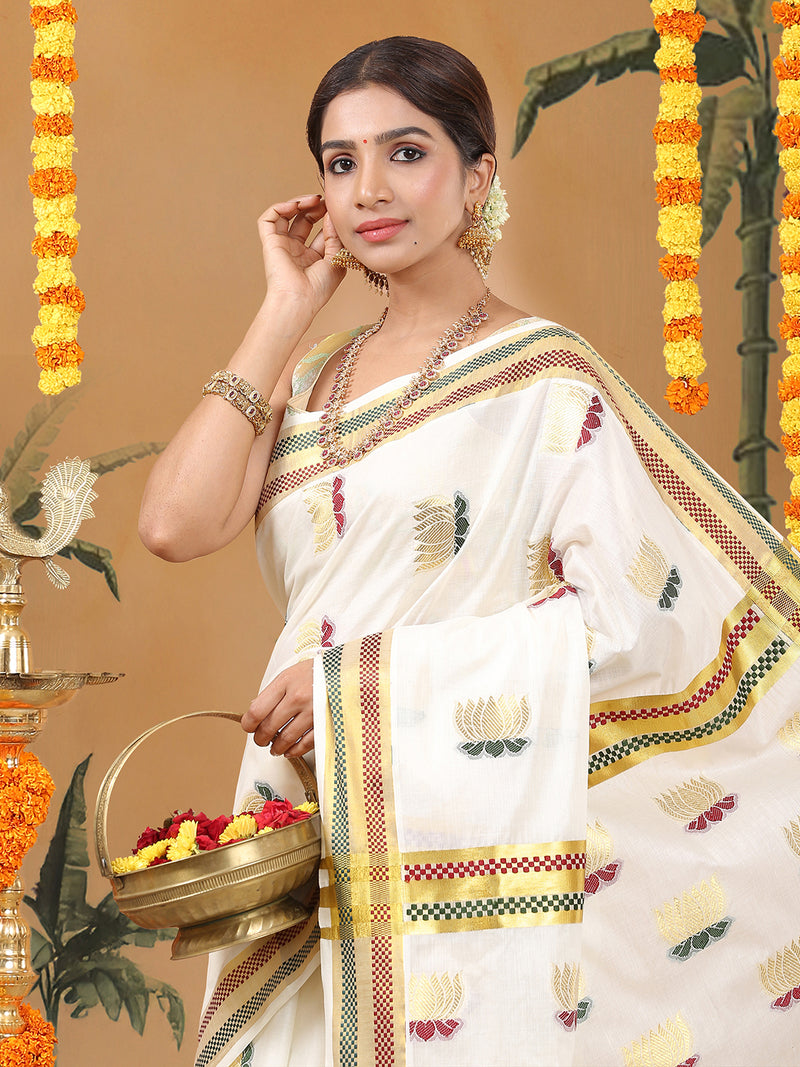 Woman in a traditional white saree with decorative patterns, holding a basket, against a decorated background.
